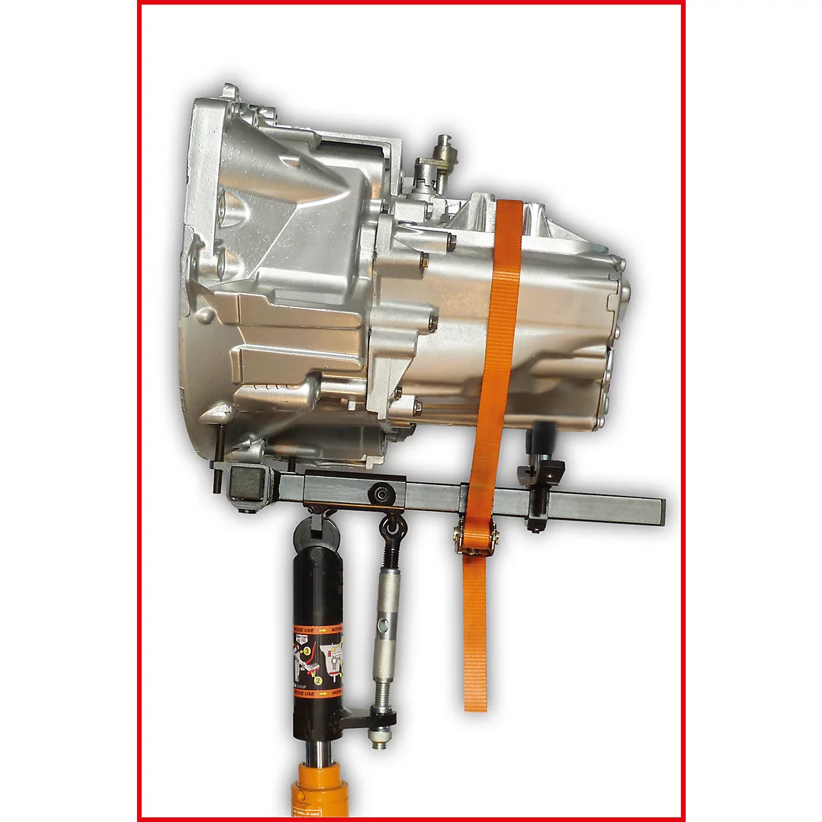 Getriebe auf Hebebühne fixiert mit Gurt. Helle Metalloberfläche, orangefarbener Gurt.